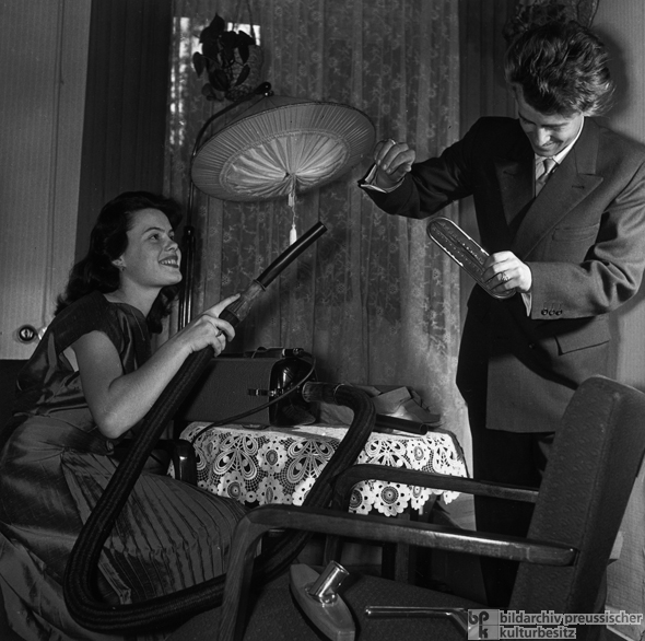 Versorgung mit Konsumgütern: Junges Paar testet neuen Staubsauger (1956)